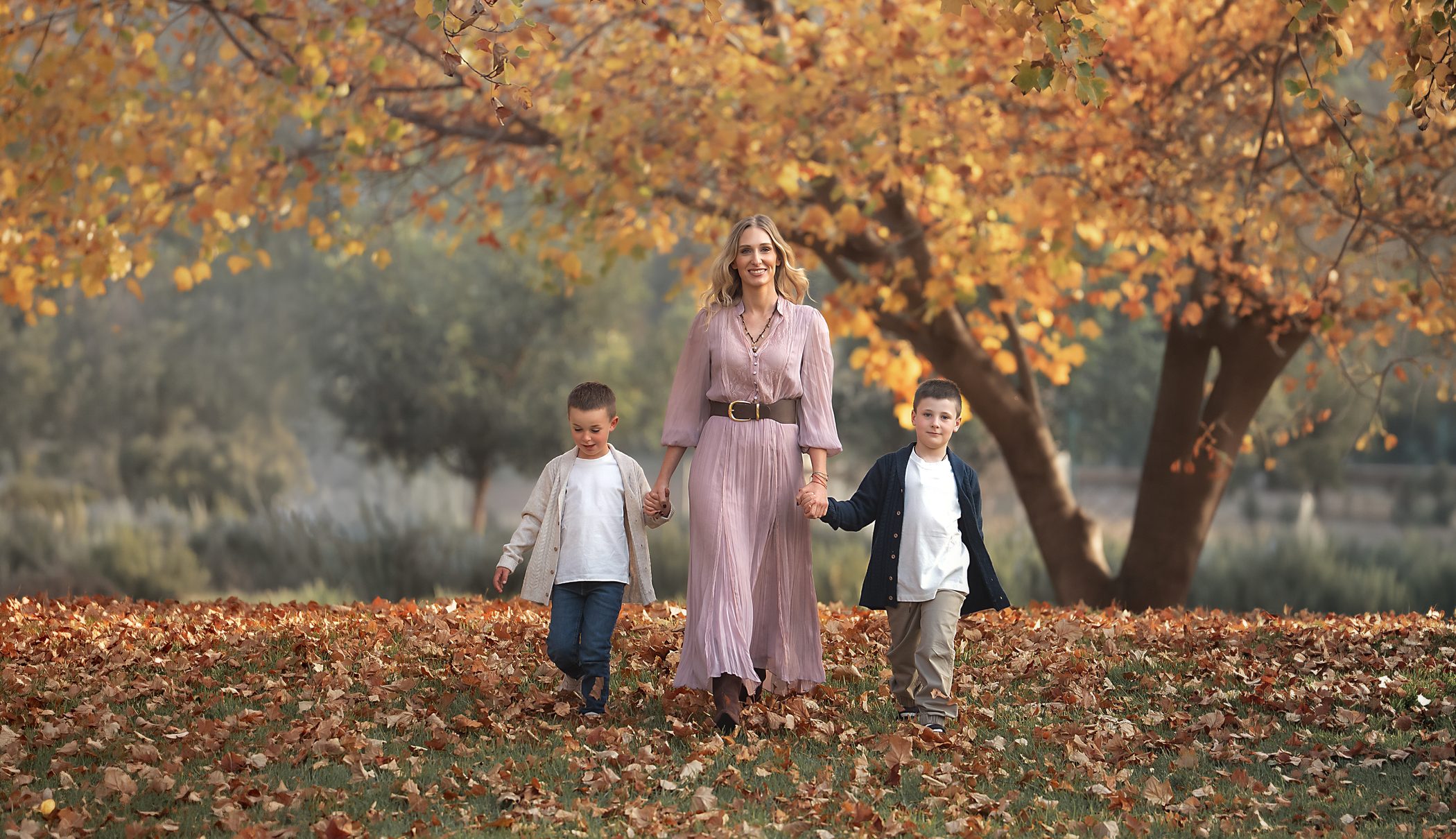 Familia caminando entre hojas de otoño